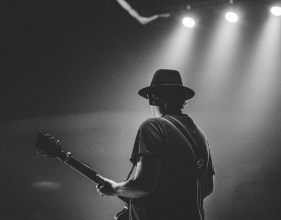 Cantante tocando guitarra en concierto de música country