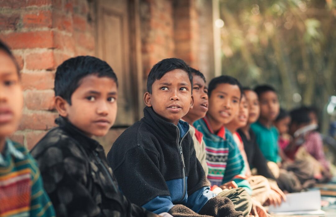 Niños sentados al aire libre aprendiendo juntos, educación inclusiva