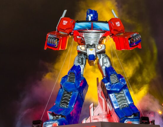 Estatua gigante de Optimus Prime iluminada de noche