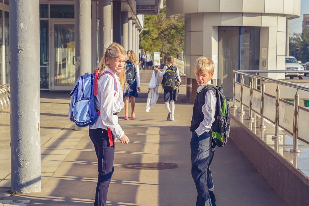 Dos estudiantes con mochilas camino a la escuela durante el regreso a clases