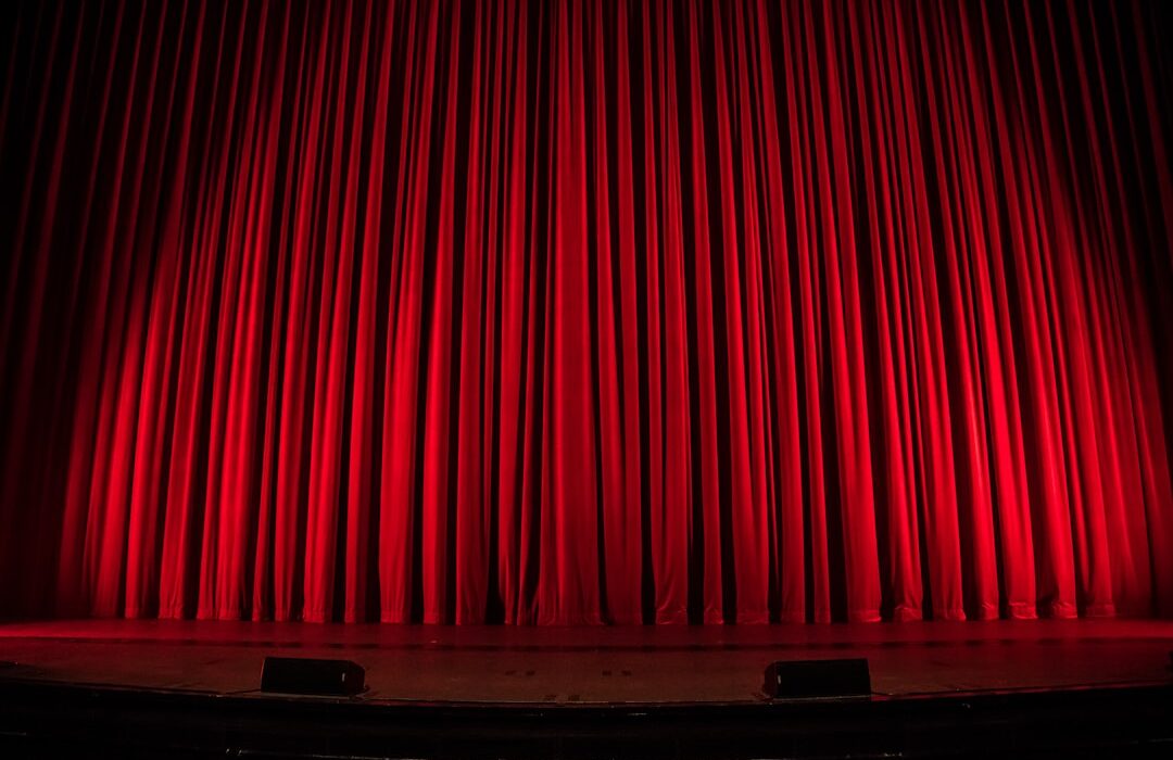 Actor en escenario de teatro con iluminación dramática