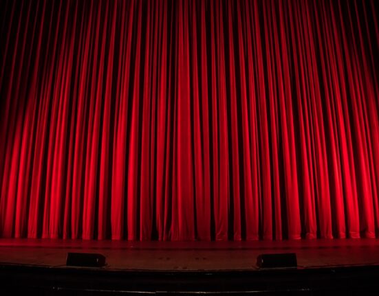 Actor en escenario de teatro con iluminación dramática